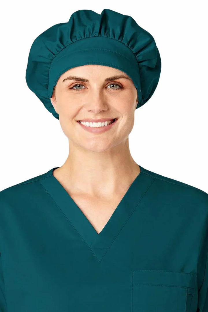 A young female Surgeon wearing a WonderWink Women's Bouffant Scrub Cap in Caribbean Blue.