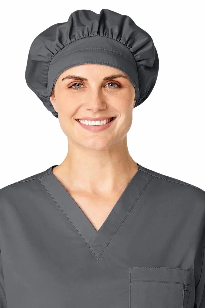 A young female nurse displaying the WonderWink Women's Bouffant Scrub Cap in Pewter (Grey) on a white background.