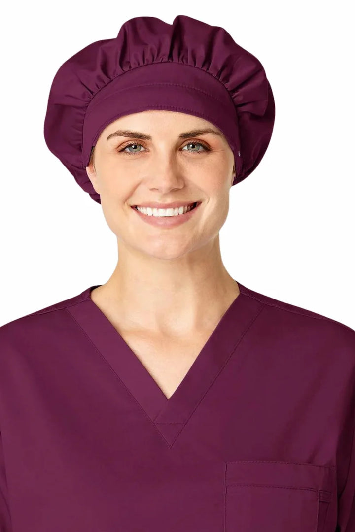 A young female Surgeon showcasing the WonderWink Women's Bouffant Scrub Cap in Wine featuring a sweat absorbing terry band.