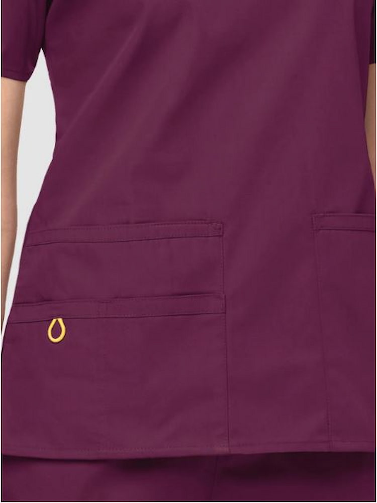An up close image of the WonderWink Women's Bravo V-neck Scrub Top in Wine size Small featuring a triple pocket with hidden mesh pocket & signature ID bungee loop.