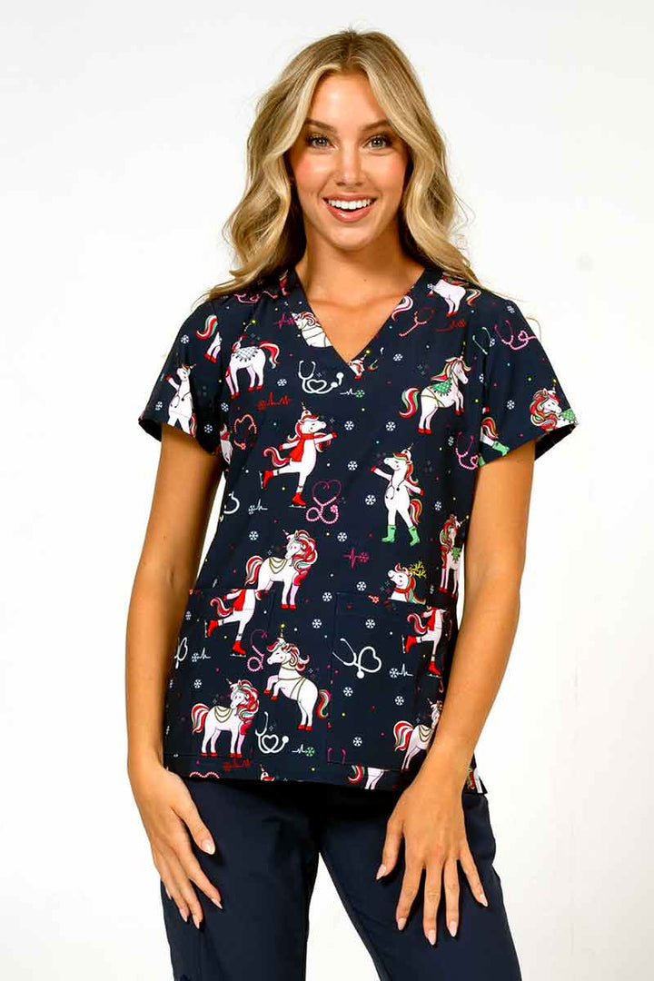 A young female Nurse Practitioner wearing a Meraki Sport Women's Print Scrub Top in "Jolly Nursicorn" size large featuring a v-neckline & short sleeves.