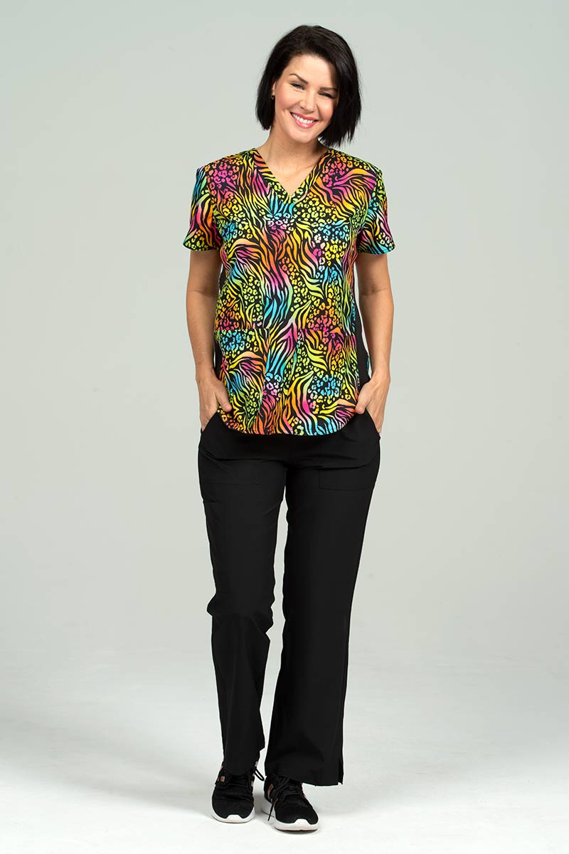 A young female LPN wearing a Meraki Sport Women's Print Scrub Top in "Bold Moves" size Large featuring stylish seaming throughout to ensure a flattering fit.
