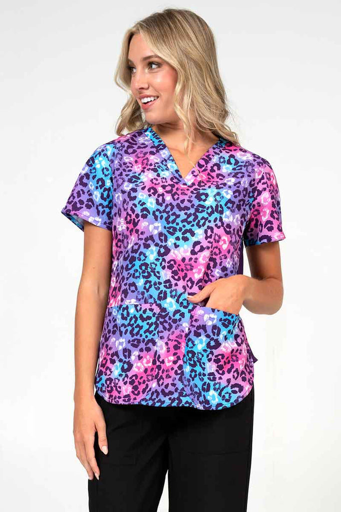 Young healthcare professional wearing a Meraki Sport Women's Print Scrub Top in "Wild One" size extra-small featuring stretch side panels for a comfortable all day fit.