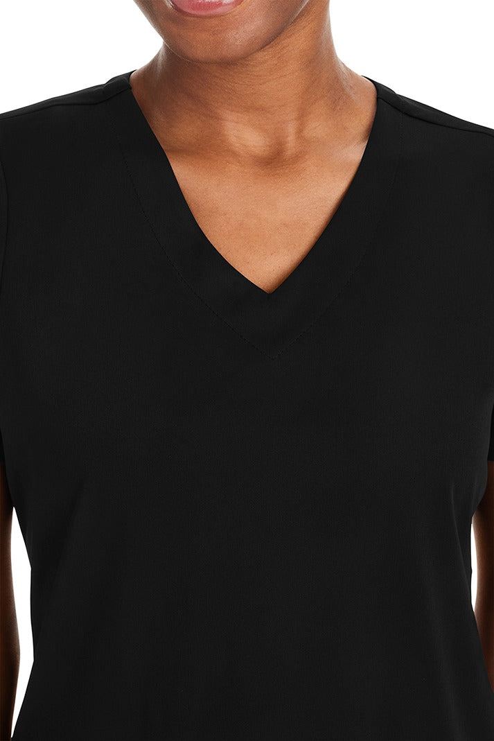 A female physical therapist wearing a Purple Label Women's Andes Curved V-Neck Scrub Top in "Black" size XS featuring a curved V-neckline.