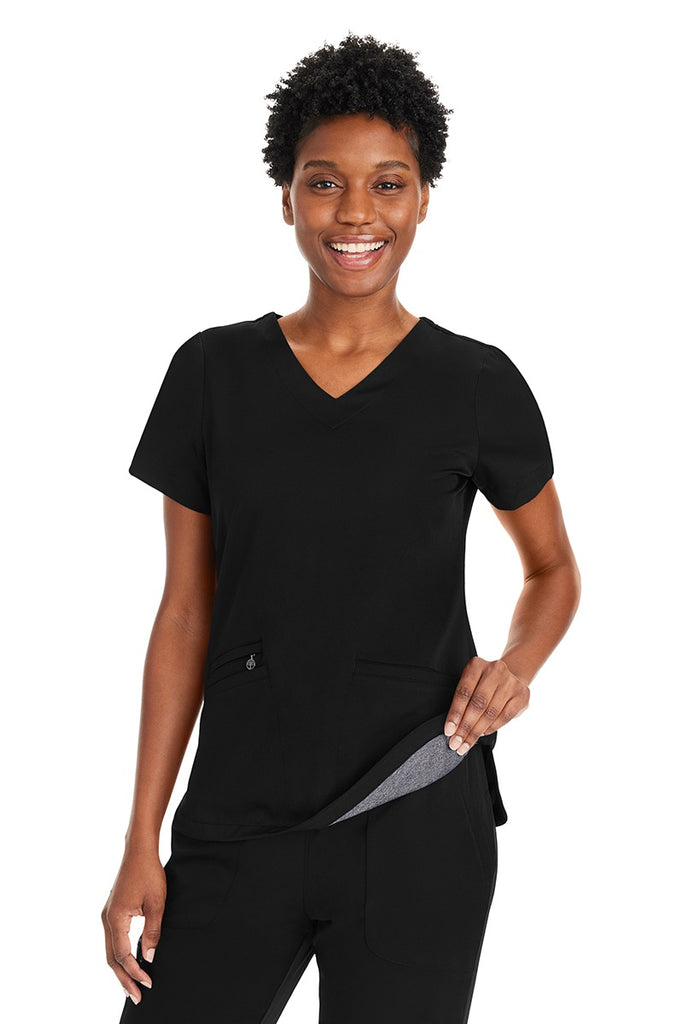 A young female LPN wearing a Purple Label Women's Andes Curved V-Neck Scrub Top in "Black" size Large featuring a luxurious 4-way stretch fabric.