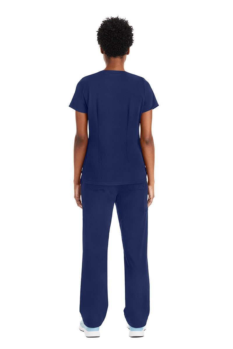 A young female Registered Nurse wearing a Women's Andes Curved V-Neck Scrub Top from Purple Label by Healing Hands featuring a Polyester/Spandex blend that provides a tough, long-lasting product.
