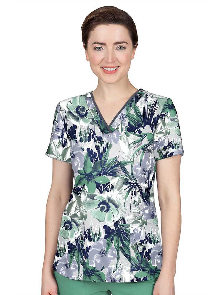 A young female Pediatric Nurse wearing a Premiere by Healing Hands Women's Amanda Printed Scrub Top in "Morning Bloom" size Large featuring a v-neckline with contrast binding.