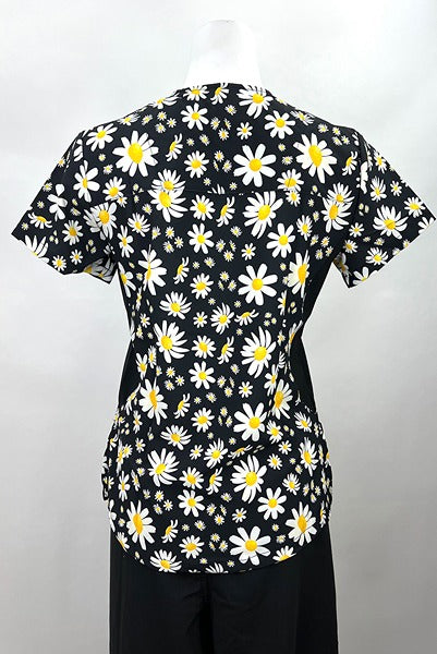 An image of the back of the Revel Women's Mock Wrap Print Scrub Top in "Daisy Power" size 2XL featuring side stretch panels & side slits for additional range of motion throughout the day.