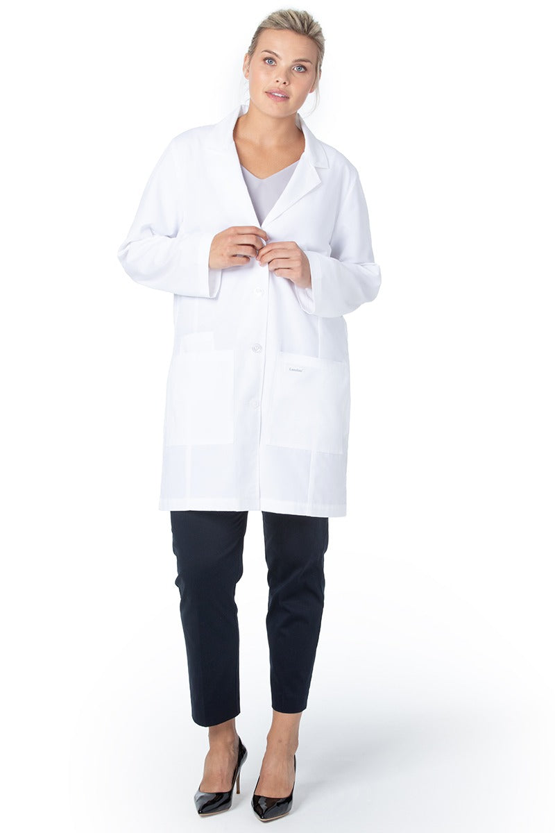 A young female Medical Practitioner wearing a Landau Women's 3-Pocket Front Lab Coat in White Sanded size XL featuring a total of 3 pockets & side slits for easy access to pants.