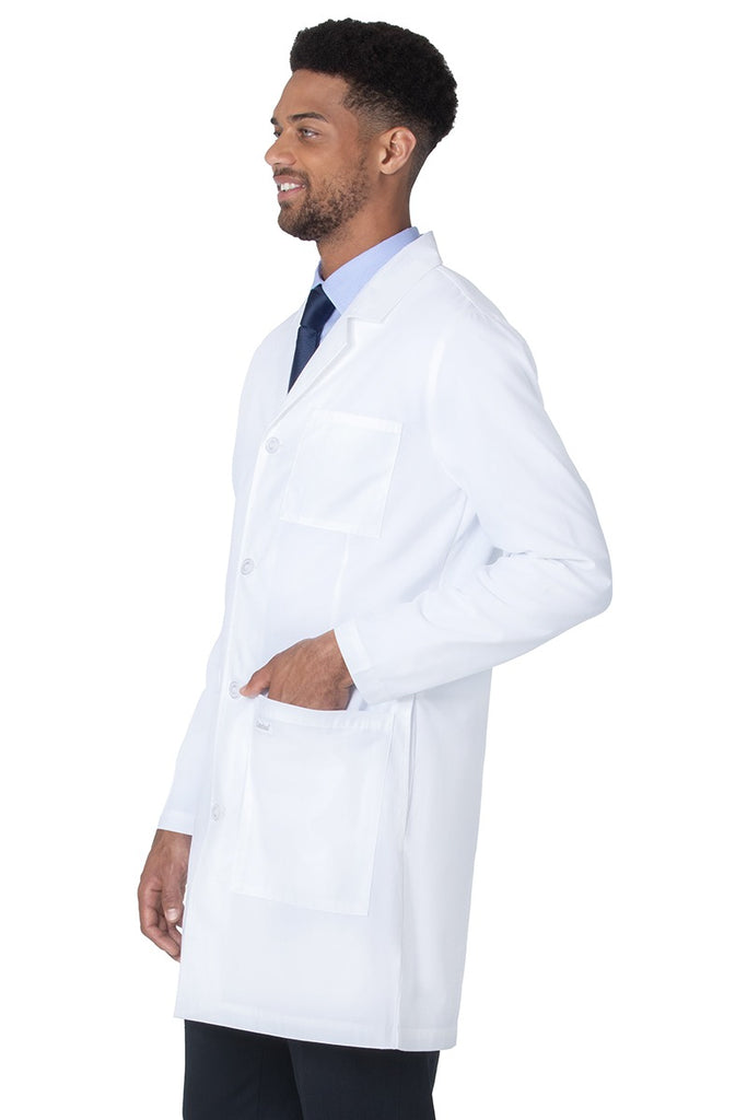A young male Lab Technician wearing a Landau Unisex 4-Pocket Mid-Length Lab Coat in White Sanded size 5XL featuring 2 front patch pockets.
