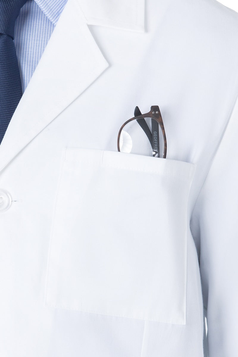 A male Chemist wearing a Landau Unisex 4-Pocket Mid-Length Lab Coat in White Sanded size Large featuring a front left chest pocket for additional on the job storage needs.