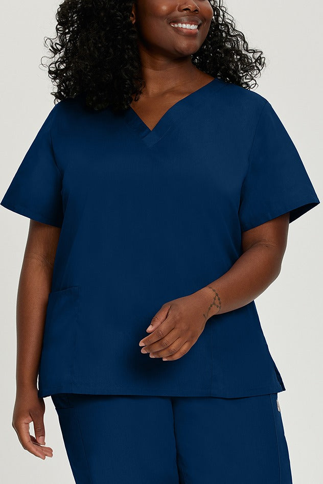 A young female Physical Therapist wearing a Landau ScrubZone Women's V-Neck Scrub Top in True Navy size 2XL featuring a fade resistant, easy care fabric.