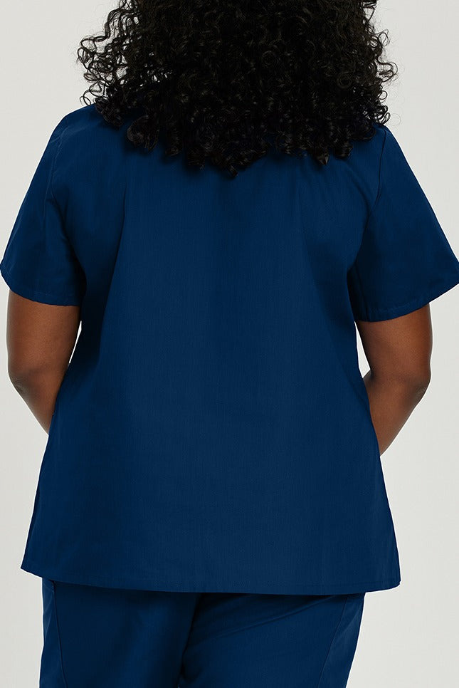 A young female Healthcare Hero wearing a Landau ScrubZone Women's V-Neck Scrub Top in True Navy size 4XL featuring a roomy silhouette with a total of 3 pockets. 
