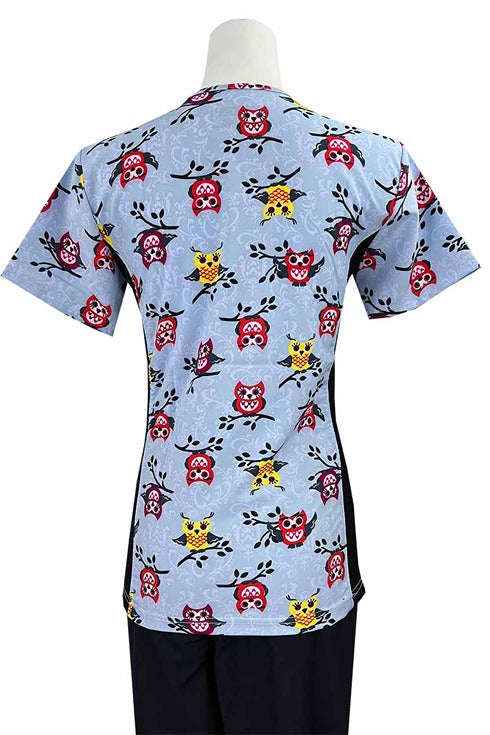 An Essentials Women's Mock Wrap Side Panels Scrub Top in "Hootie" featuring 2 front patch pockets & 1 exterior utility pocket on the wearer's right side.