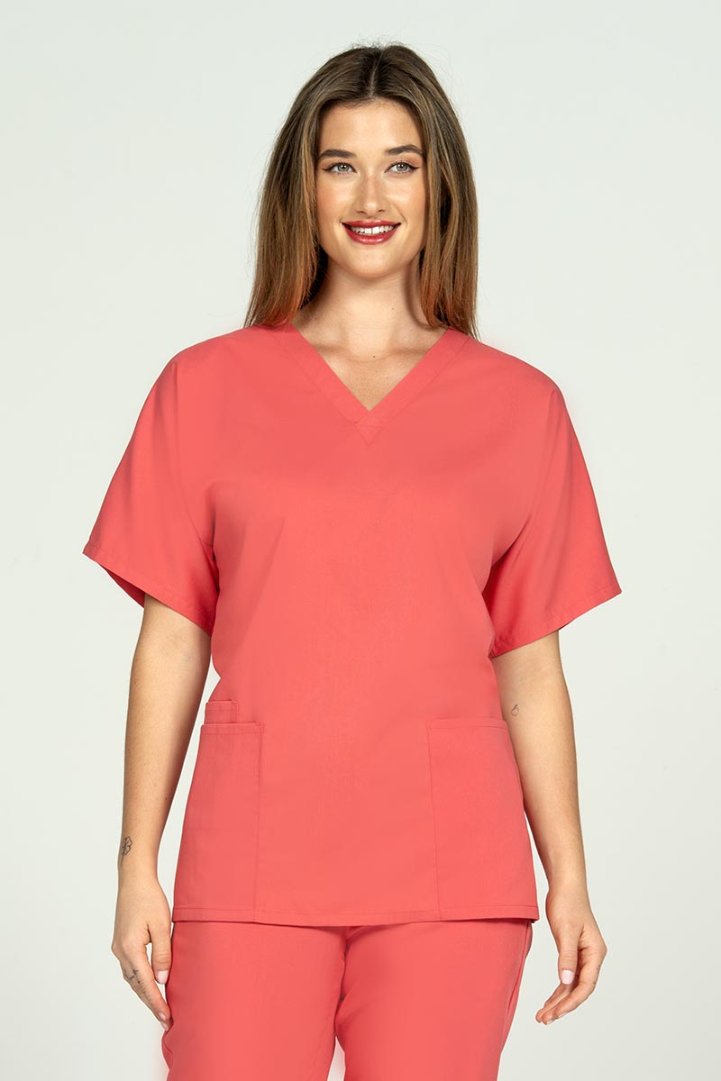 A female Dental Assistant wearing an Epic by MedWorks Unisex V-neck Scrub Top in Coral featuring a V-neckline with short sleeves. 