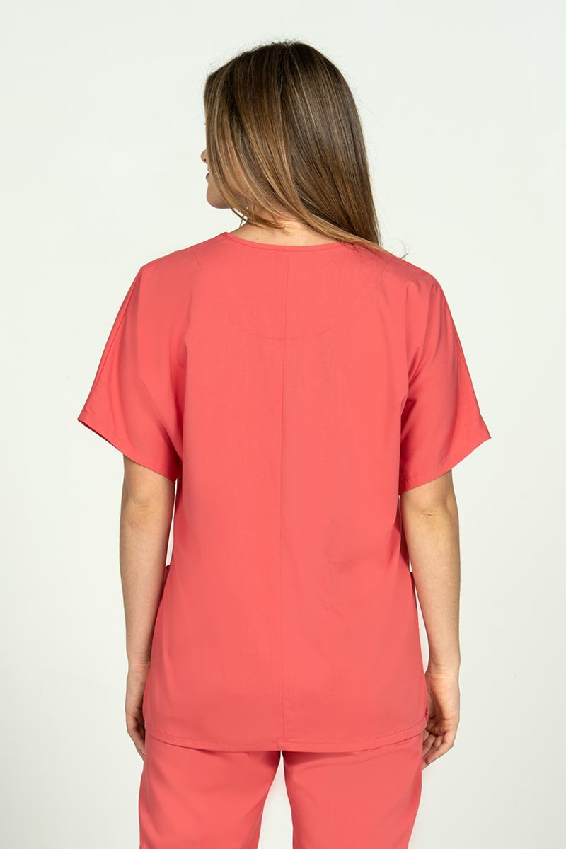 A young female Nursing Assistant wearing an Epic by MedWorks Unisex V-neck Scrub Top in Coral size large featuring a center back length of 27.5".