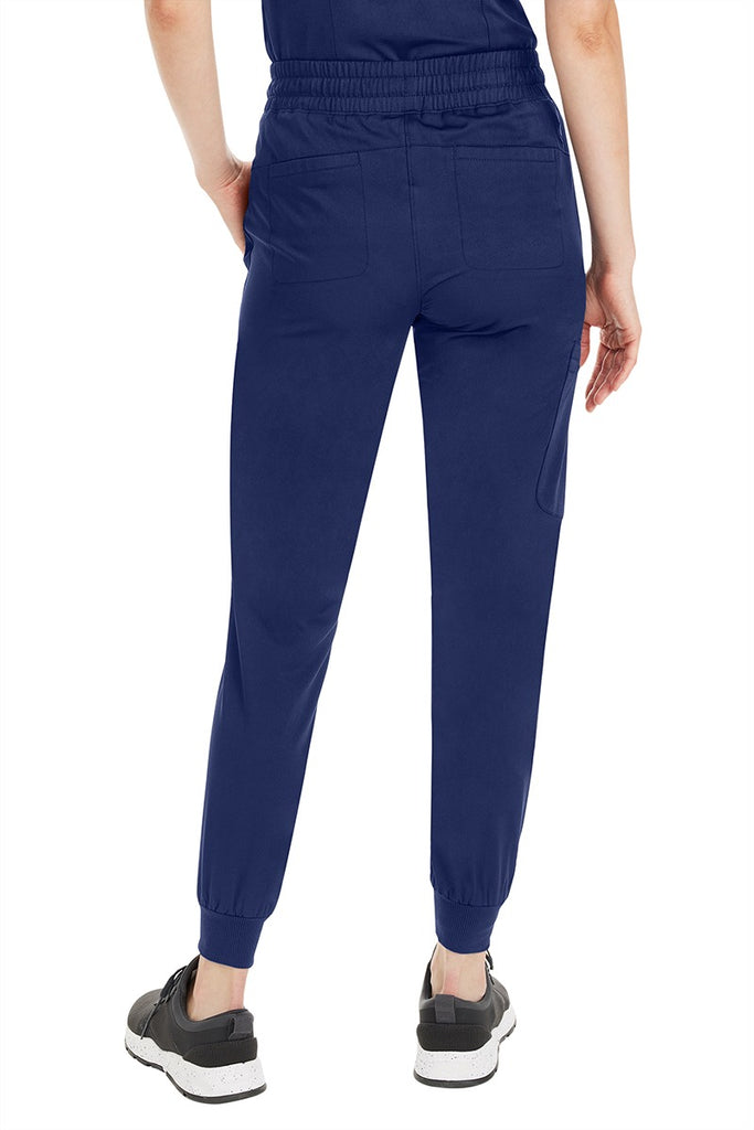 A young female Pharmacy Technician wearing a Purple Label by Healing Hands Women's Aspen Jogger Scrub Pant in "Navy" size medium petite featuring 2 back patch pockets.