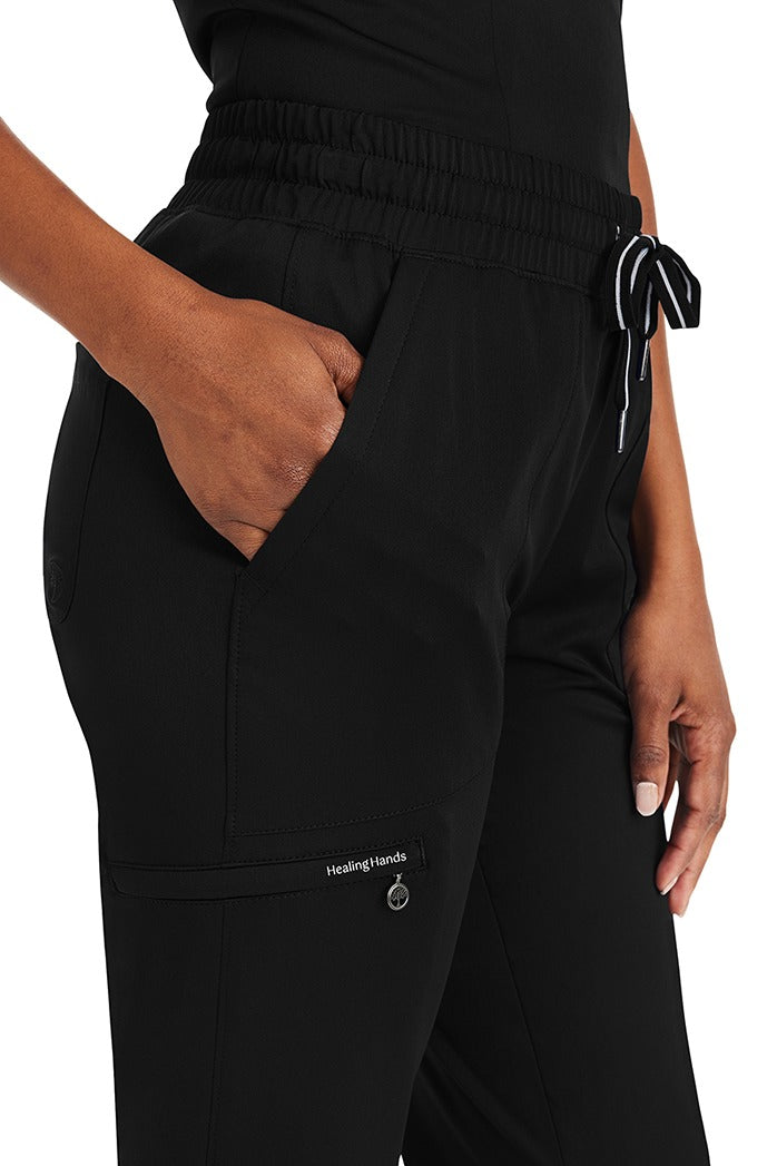 A female Nursing Assistant wearing a Purple Label Women's Knit Lined Alaskan Pant from Healing Hands in "Black" size XL featuring 2 front slash pockets.