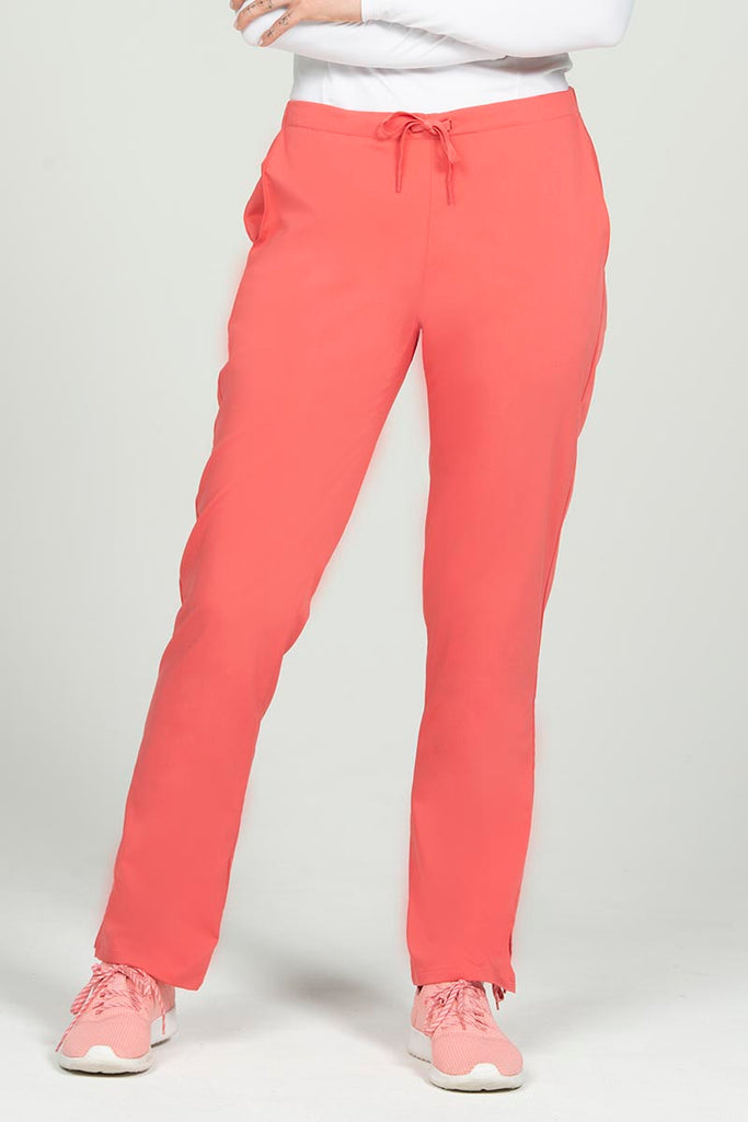 A young female Nurse wearing an Epic by MedWorks Women's Natural Rise Flare Leg Scrub Pant in Coral size XS featuring a drawstring waist with back elastic.