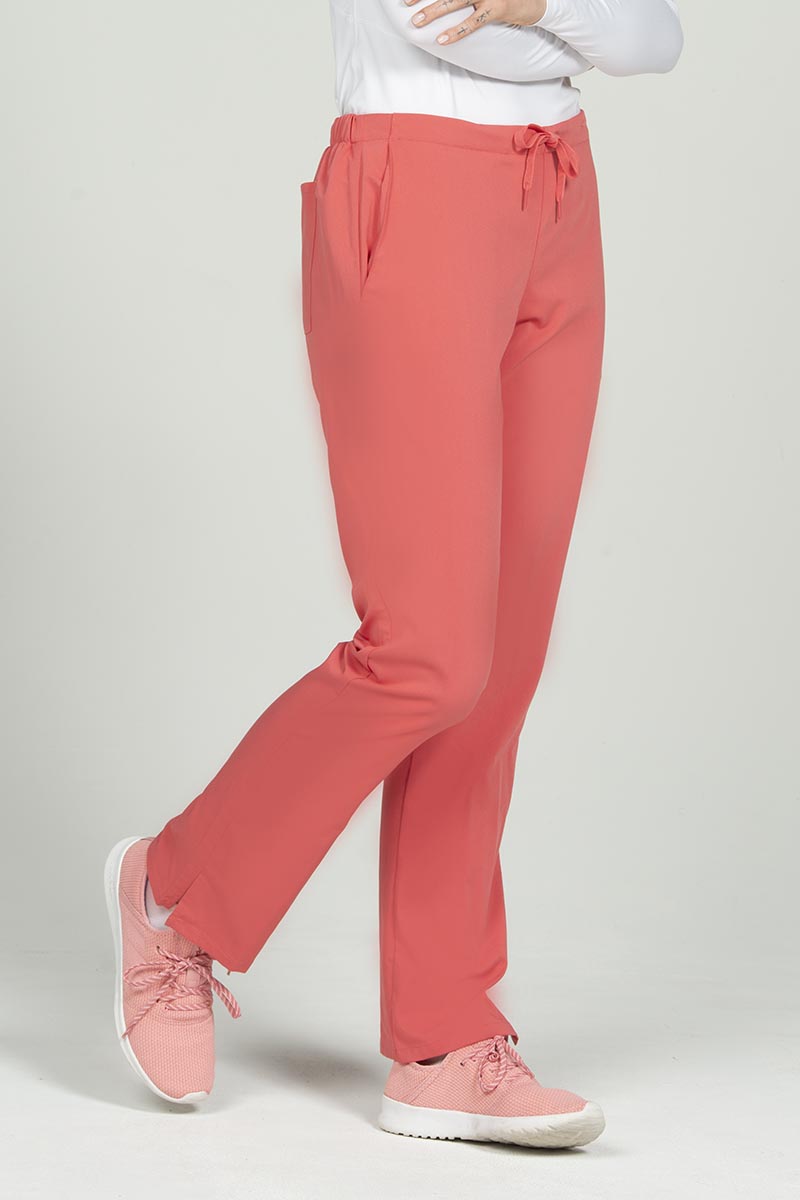 A female Phlebotomist wearing an Epic by MedWorks Women's Natural Rise Flare Leg Scrub Pant in Coral size 3XL featuring side slits.