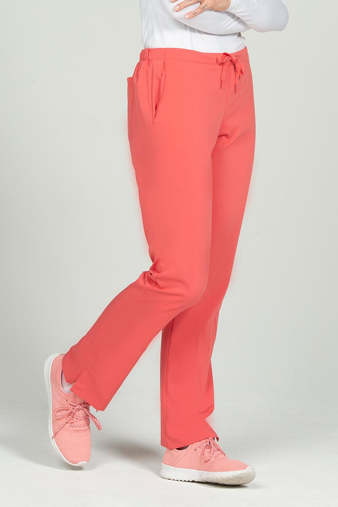 A female Phlebotomist wearing an Epic by MedWorks Women's Natural Rise Flare Leg Scrub Pant in Coral size 3XL featuring side slits.