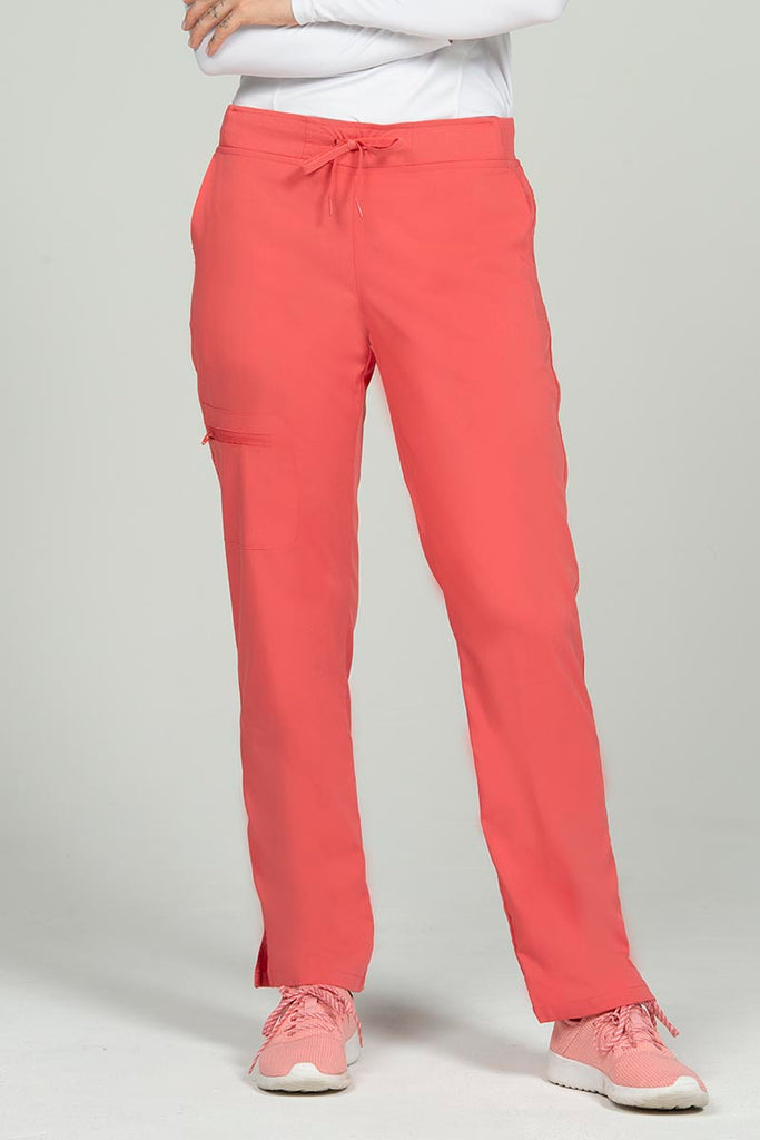 A young female Phlebotomist wearing an Epic by MedWorks Women's Skinny Yoga Scrub Pant in Coral size 3XL featuring a knit waistband.