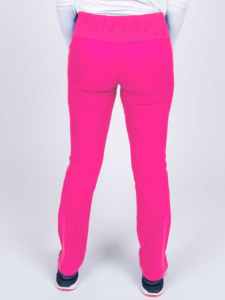 Nurse wearing an Epic by MedWorks Women's Skinny Yoga Scrub Pant in shocking pink with an adjustable drawstring and knit waistband.