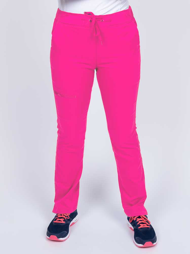 Young woman wearing an Epic by MedWorks Women's Skinny Yoga Scrub Pant in shocking pink with side slits for additional range of motion.