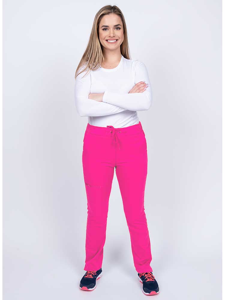 Young woman wearing an Epic by MedWorks Women's Blessed Skinny Yoga Scrub Pant in shocking pink with an adjustable waistband.