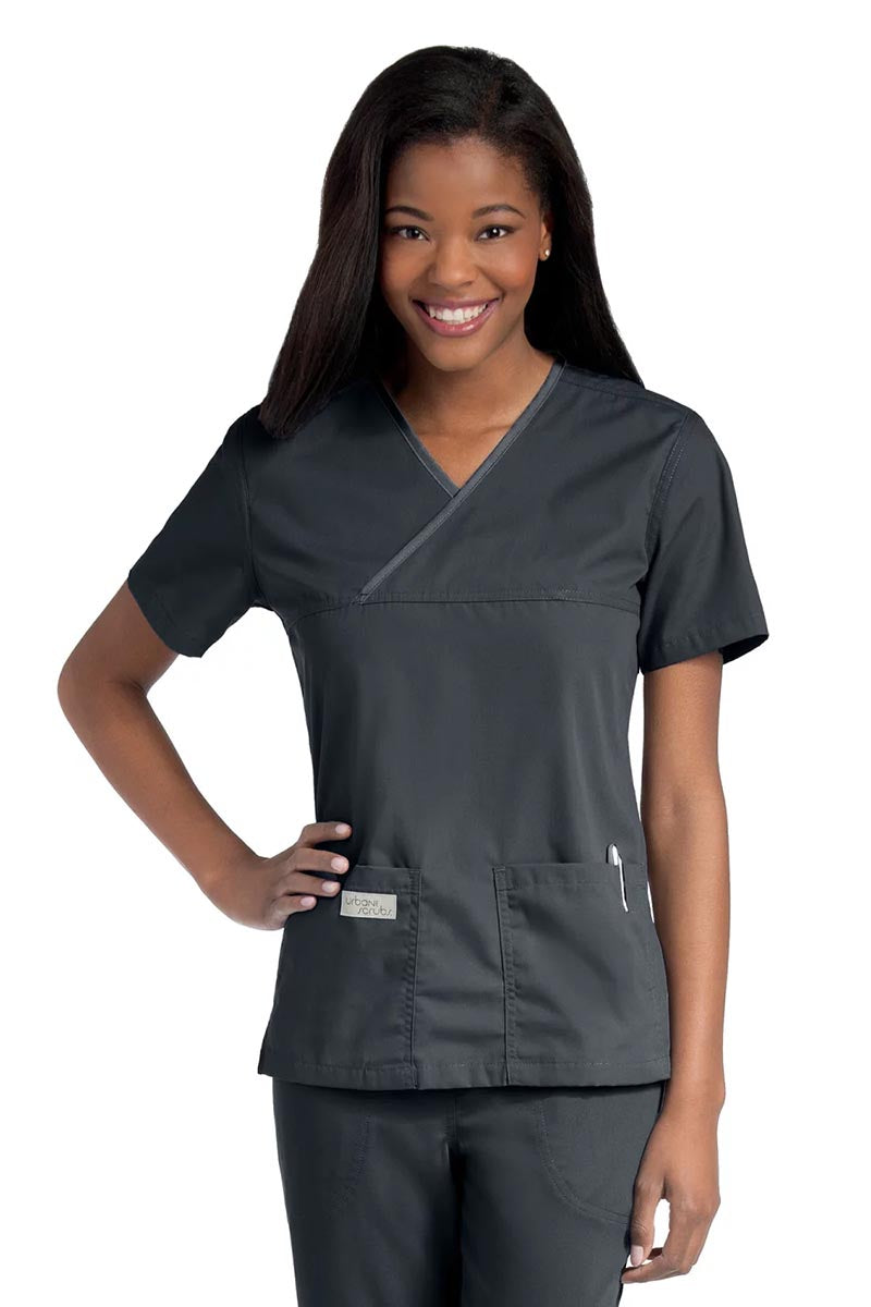 Young lady wearing an Urbane Essentials Women's Crossover Scrub Top in "Graphite" featuring a unique crossover neckline for a flattering fit.