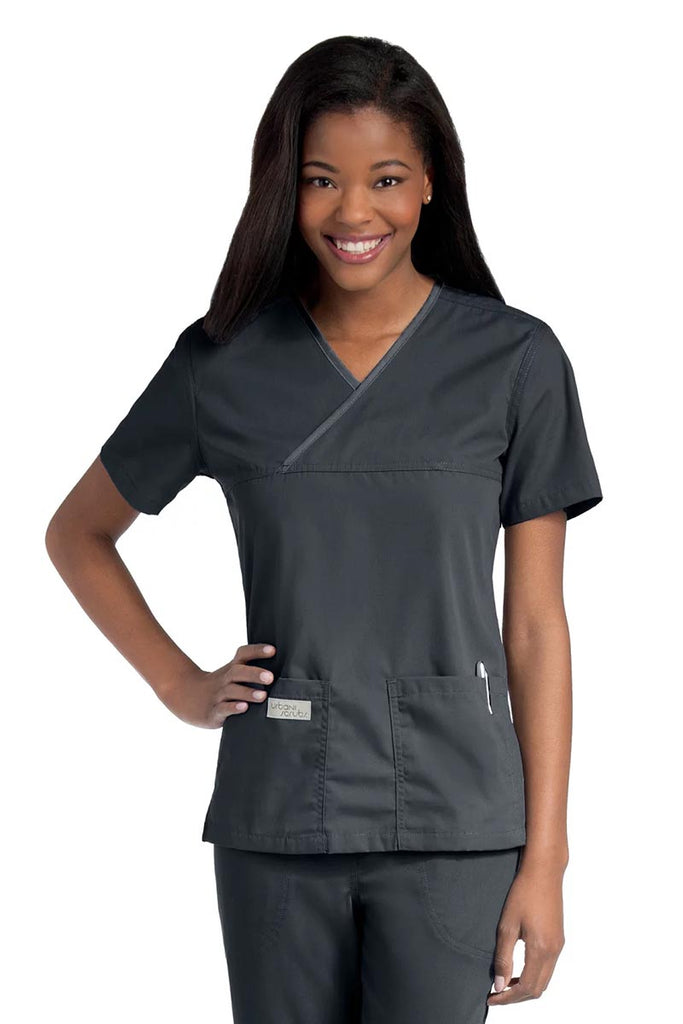 Young lady wearing an Urbane Essentials Women's Crossover Scrub Top in "Graphite" featuring a unique crossover neckline for a flattering fit.