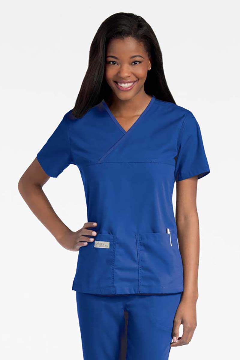 Young lady wearing an Urbane Essentials Women's Crossover Scrub Top in "Royal Blue" featuring a unique crossover neckline for a flattering fit.