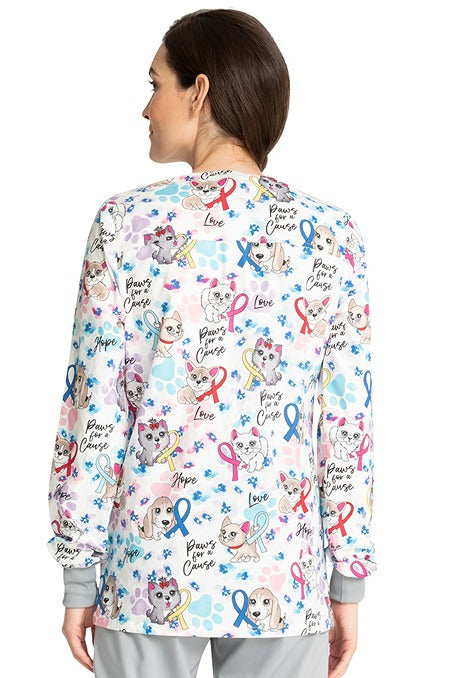A young Home Care Registered Nurse wearing a Cherokee Women's Snap Front Print Scrub Jacket in "Paws for a Cause" featuring a center back length of 28".