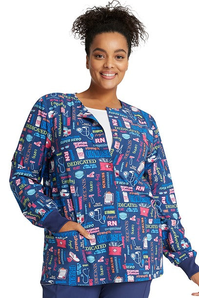 A young female Certified Nurse wearing a Women's Print Snap Front Jacket from Cherokee Uniforms in "Scrub Life" featuring a modern classic fit.
