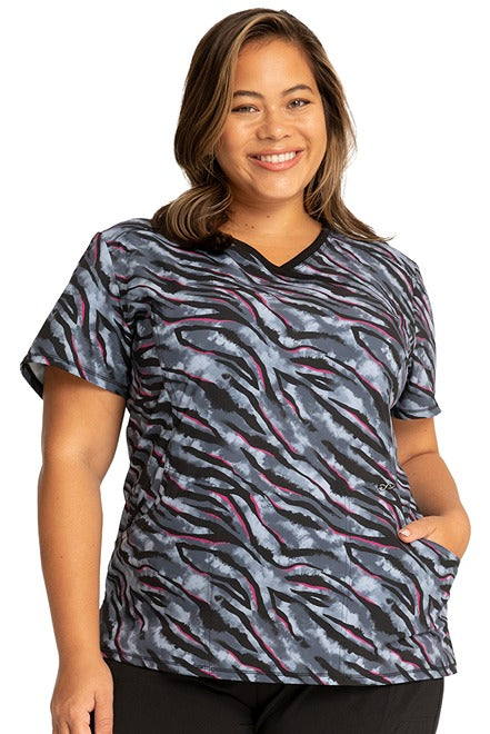 A young female LPN wearing a Women's Mock Wrap Print Top from Cherokee Infinity in "Wild for Tie Dye".