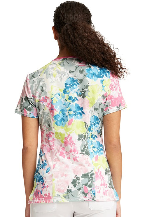A young LPN wearing a Cherokee Infinity Women's Round Neck Print Top in "Brush Away Blooms" featuring a center back length of 26".