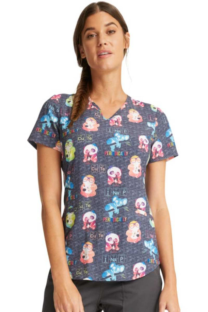 A young female LPN wearing a Cherokee Women's V-neck Print Scrub Top in "Science Friends" featuring a modern classic fit.