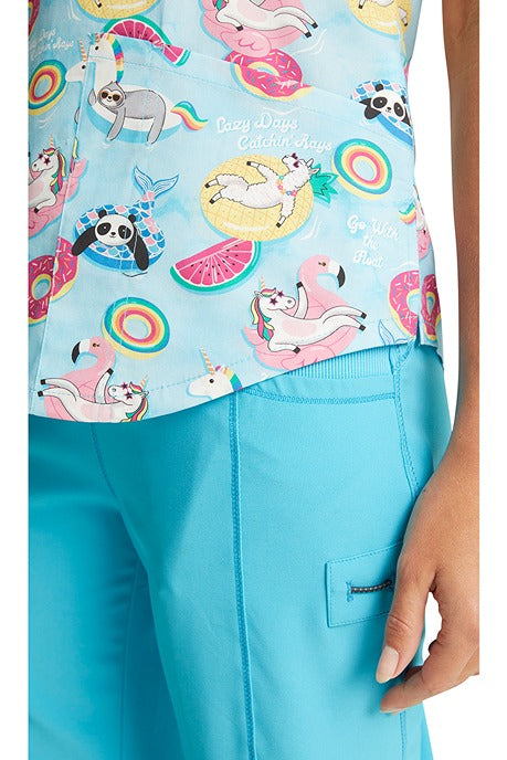 A young nurse wearing a Cherokee Women's V-Neck Print Scrub Top in "Go With The Float" featuring Tooniforms inspired design.