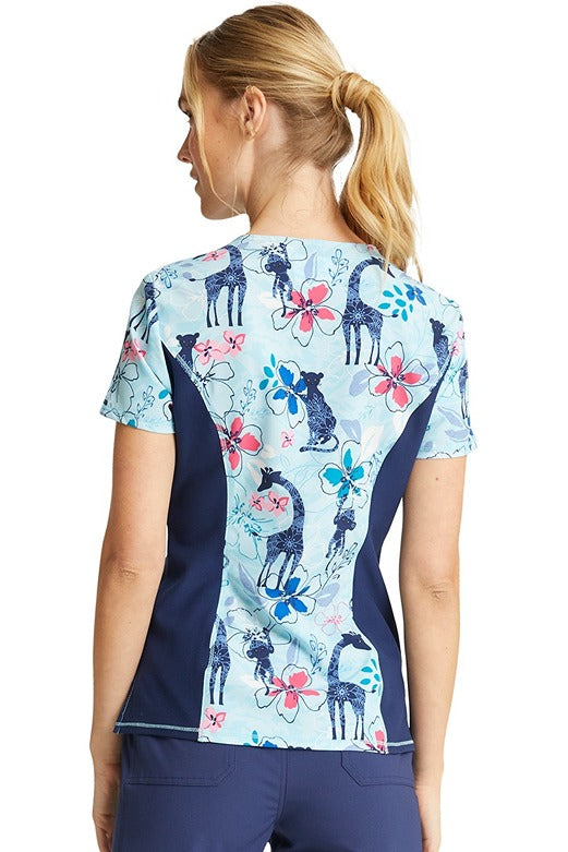 A female Pediatrician wearing a Cherokee Women's V-neck Print Scrub Top in "Jungle Blues" size Medium featuring a center back length of 25".