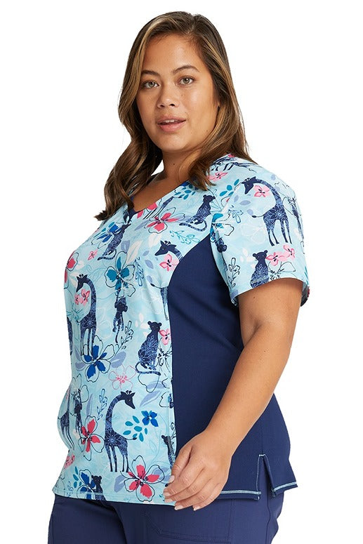 A female Healthcare Professional wearing a Cherokee Women's V-neck Print Scrub Top in "Jungle Blues" size 3XL featuring front yoke seams for additional shaping.