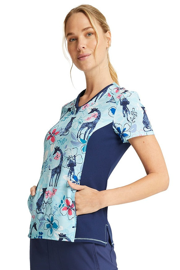 A young Female Phlebotomist wearing a Cherokee Women's V-neck Print Scrub Top in "Jungle Blues" size Large featuring stylish seaming throughout.