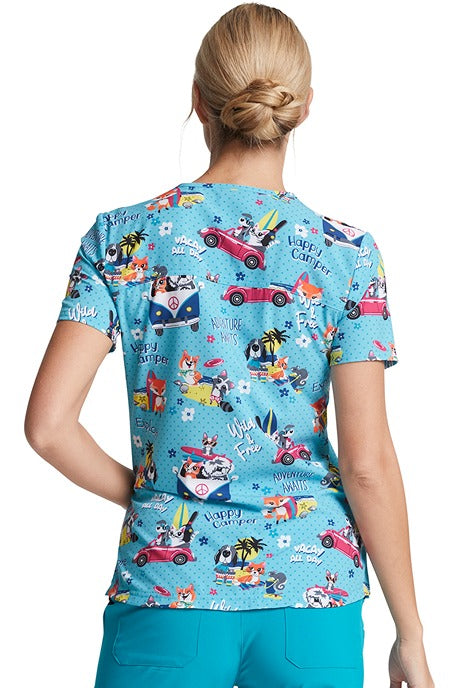 A female Home Care Registered Nurse wearing a Dickies Women's V-neck Print Scrub Top in "Vacay All Day" featuring front & back yoke seams.