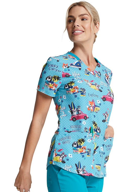 A young nurse wearing a Women's V-Neck Print Scrub Top from Dickies Medical in "Vacay All Day" featuring a contemporary fit.