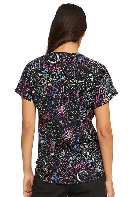 A young female LPN wearing a HeartSou; Women's Round Neck Print Scrub Top in "Celestial Twist" featuring a center back length of 26".