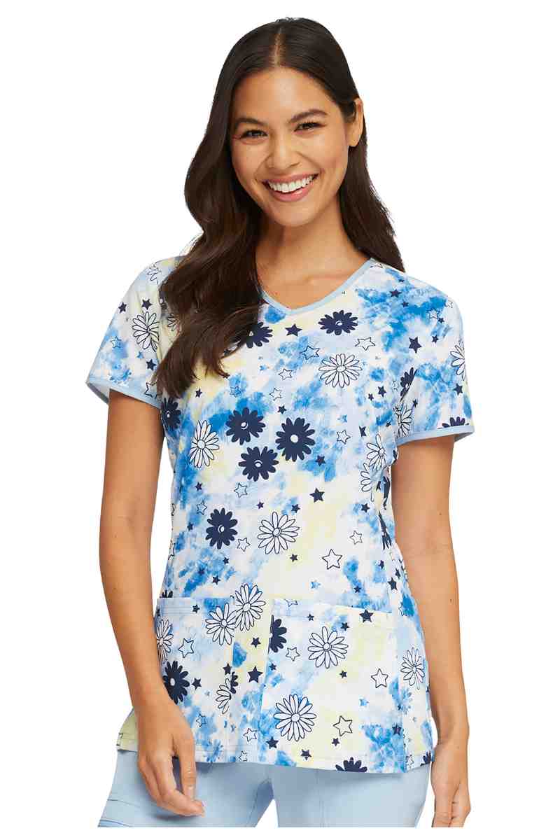 A young female Occupational Therapist wearing a HeartSoul Women's V-neck Print Scrub Top in "Daisy Spirit" size medium featuring a contemporary fit.