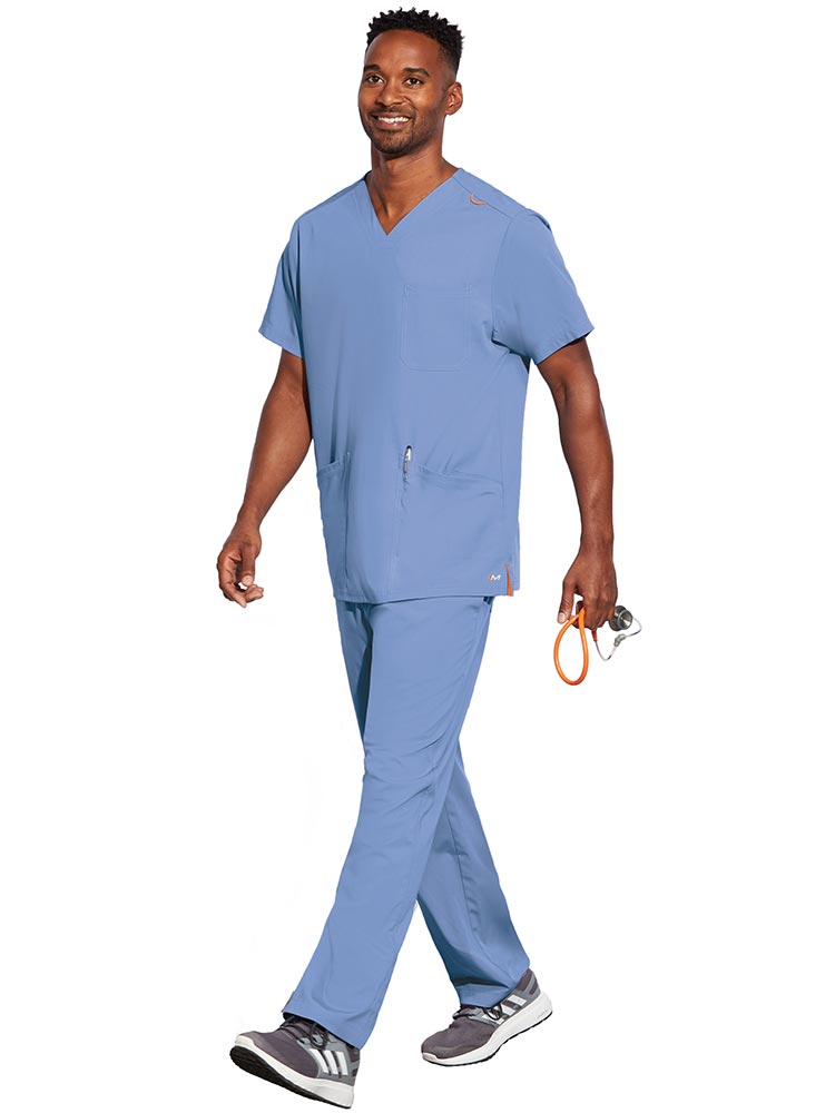 Young male LPN wearing a Unisex V-Neck Scrub Top from Barco Motion in Ceil size XL featuring a total of 5 pockets for all of your daily storage needs.