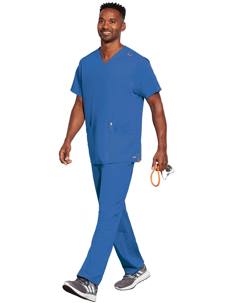 Young male LPN wearing a Unisex V-Neck Scrub Top from Barco Motion in Royal size XS featuring a total of 5 pockets for all of your daily storage needs.