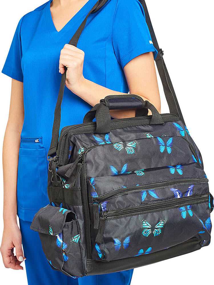 A young female CNA carrying the Nurse Mates Ultimate Medical Bag in "Midnight Butterfly" featuring a hardwearing shoulder strap.