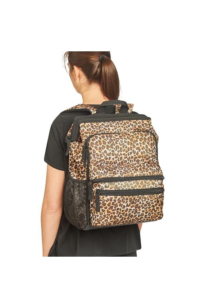 A young female Registered Nurse wearing a Nurse Mates Ultimate Backpack in "Cheetah Print" featuring a variety of pockets & compartments to fit everything from laptops, medical supplies & more.