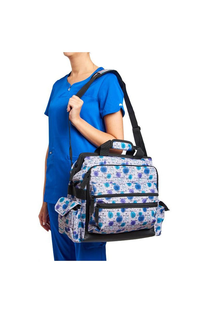 A young female RN carrying a Nurse Mates Ultimate Medical Bag in "Mantra Woods" featuring an adjustable nylon strap.